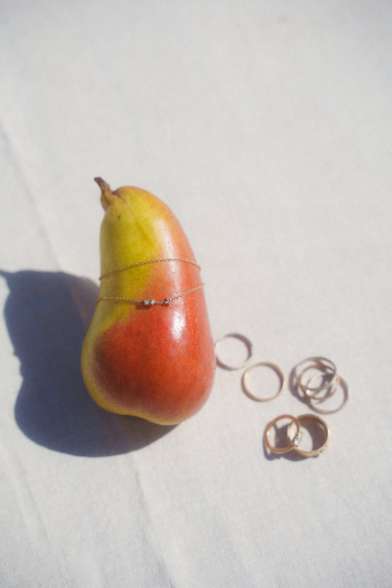 The Kataia necklace and various Katie Rose Jewellery displayed with a pear. 