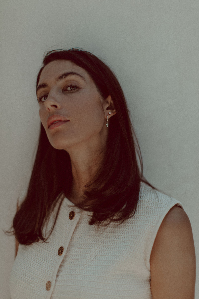 Model wears Therese earrings, in 9ct gold with diamonds paired with diamond stud. 