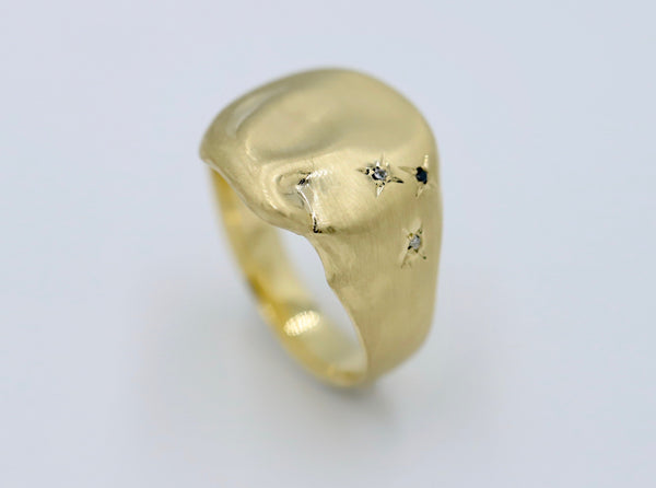In the stars signet ring, organic shaped signet ring with small diamonds star set down one side