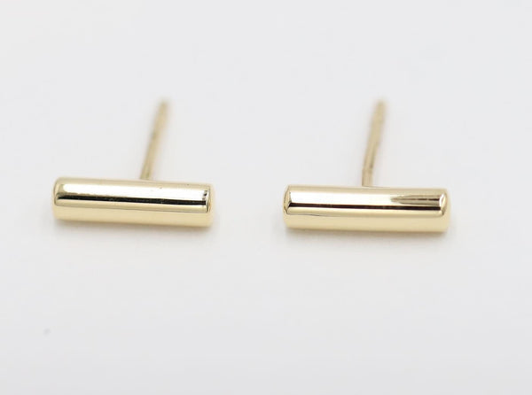 A pair of thick round bar stud earrings in white gold color.